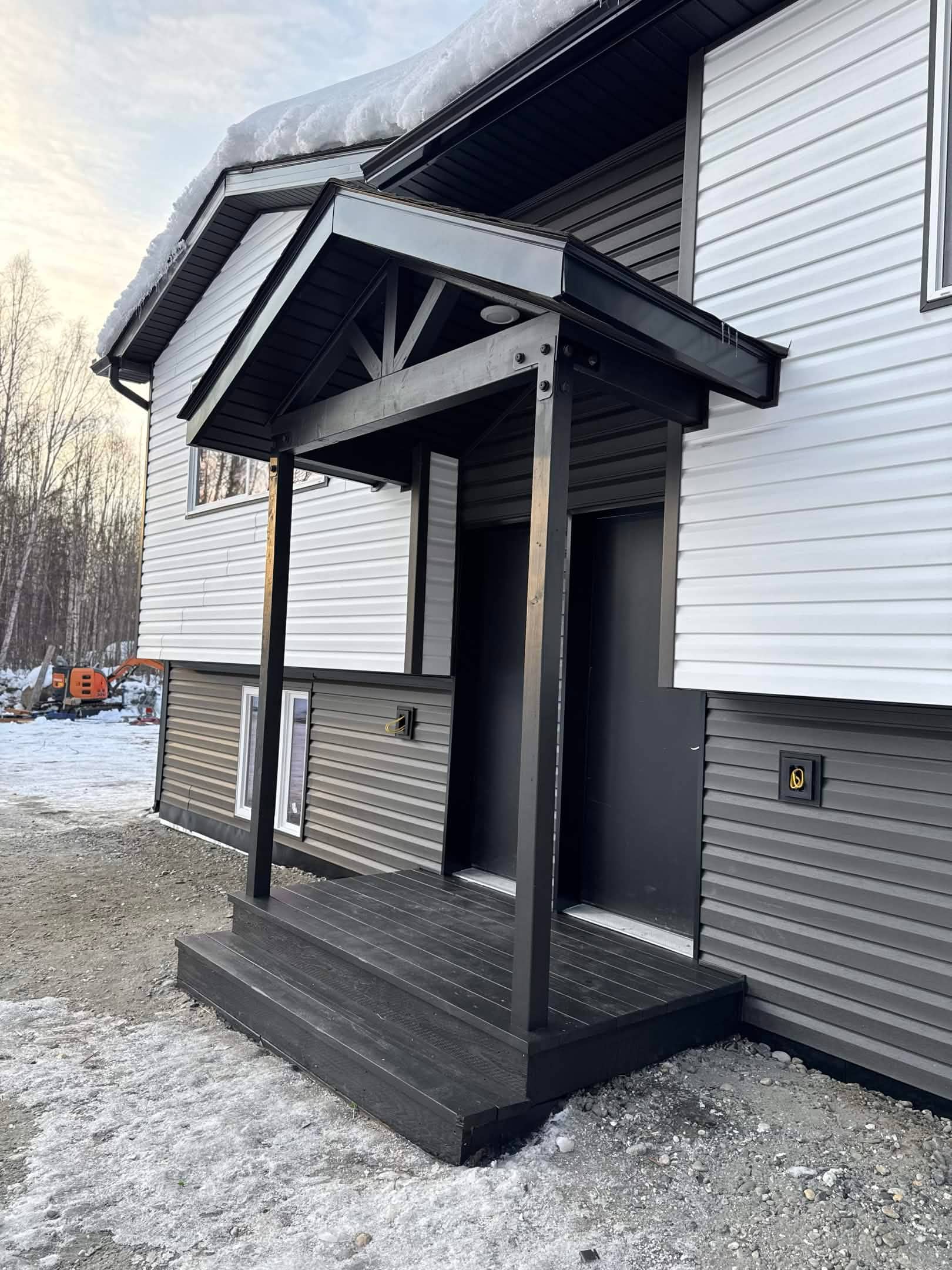 Finished entryway with covered porch and dark trim, Fairbanks
