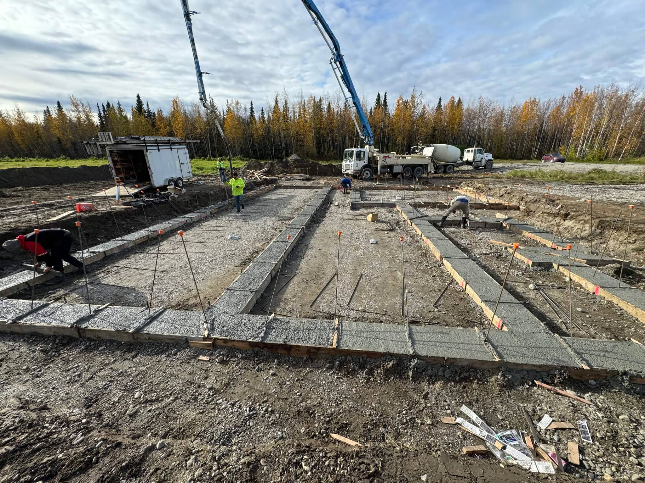 Foundation concrete pour with crane and crew on new build site, Fairbanks Alaska